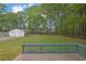 Exterior shot of the fenced backyard featuring green grass and a two car garage at 3430 Pate Rd, Snellville, GA 30078