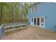 View of the wooden deck with a picnic table looking toward the double doors to the home at 3430 Pate Rd, Snellville, GA 30078