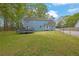 Back exterior of the home showcases a spacious yard with a deck and fenced perimeter at 3430 Pate Rd, Snellville, GA 30078