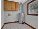 Cozy utility room with tile flooring, wooden cabinets and window for natural light at 3430 Pate Rd, Snellville, GA 30078