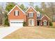 Attractive two-story red brick home with mature landscaping and an attached two-car garage at 5952 Edenfield Nw Dr, Acworth, GA 30101
