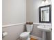 Cozy powder room featuring a pedestal sink, toilet, and decorative mirror at 5952 Edenfield Nw Dr, Acworth, GA 30101