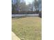 Wide shot of backyard showcasing a large green lawn and a white fence for added privacy at 10 Chapman Way, Covington, GA 30016