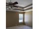 Bedroom featuring a ceiling fan, neutral walls and carpet, window, and tray ceiling at 10 Chapman Way, Covington, GA 30016