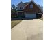 Traditional two-story brick home featuring an attached two-car garage and mature landscaping at 10 Chapman Way, Covington, GA 30016