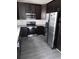Updated kitchen with stainless steel appliances, dark cabinets, granite countertops, and modern backsplash at 10 Chapman Way, Covington, GA 30016