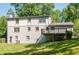Exterior back view of a two story home with a deck and a large, gently sloping green backyard at 2647 Wood Hollow Dr, Dunwoody, GA 30360