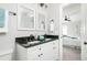 Bathroom with dual sinks, granite countertops, and a bedroom view with white bedding and a ceiling fan at 2647 Wood Hollow Dr, Dunwoody, GA 30360