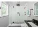 Bright bathroom featuring glass shower with black hardware, gray floor and a large window for natural light at 2647 Wood Hollow Dr, Dunwoody, GA 30360