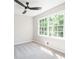 Bedroom features a ceiling fan, two windows with green views, and neutral carpet at 2647 Wood Hollow Dr, Dunwoody, GA 30360