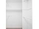 Walk-in closet features white walls, white shelves, and three metal hanging rods for storage at 2647 Wood Hollow Dr, Dunwoody, GA 30360
