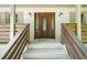 Close up of an elegant, dark wood front door with decorative glass and stylish sconces at 2647 Wood Hollow Dr, Dunwoody, GA 30360