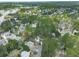 Expansive aerial view showcases a neighborhood with tree-lined streets and varied home styles, set against a backdrop of lush greenery at 3280 Peace Ln, Suwanee, GA 30024