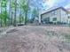 Spacious backyard featuring mature trees, a fire pit, seating area, wood pile and greenery, offering a tranquil outdoor experience at 3280 Peace Ln, Suwanee, GA 30024