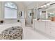 Bright bathroom featuring a soaking tub under a large arched window and a glass-enclosed shower at 3280 Peace Ln, Suwanee, GA 30024