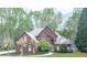 A stunning brick home framed by beautiful, mature trees and a well-manicured lawn at 3280 Peace Ln, Suwanee, GA 30024