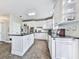 Modern kitchen with white cabinetry, a black island, stainless steel appliances, and ample counter space at 3280 Peace Ln, Suwanee, GA 30024