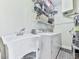 Functional laundry area equipped with a utility sink, washer, dryer, and storage shelves at 3280 Peace Ln, Suwanee, GA 30024
