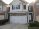 Charming two-story home with stone accents, a white three-car garage, and well-maintained landscaping at 3352 Brockenhurst Dr, Buford, GA 30519