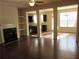 Bright open-concept living room featuring dark wood floors, fireplace, and decorative columns at 3352 Brockenhurst Dr, Buford, GA 30519