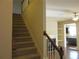 Carpeted staircase with wood railing leads to the upper level near the living room fireplace at 3352 Brockenhurst Dr, Buford, GA 30519