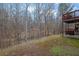 Expansive backyard view with a two-story deck, swing, grassy hill, and lush trees at 1514 Log Cabin Ln, Lawrenceville, GA 30045