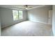 The large bedroom features plush carpet, a ceiling fan, trey ceiling and natural light from large windows at 1769 Rowland Pass, Buford, GA 30518