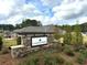 Stone sign welcomes you to the Lakecrest community, surrounded by lush greenery at 1769 Rowland Pass, Buford, GA 30518