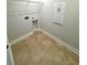 Cozy laundry area features tiled floors, wire shelving and sleek gray walls at 1769 Rowland Pass, Buford, GA 30518