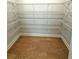 Spacious walk-in closet with wire shelving and hardwood floors, offering ample storage space at 1769 Rowland Pass, Buford, GA 30518