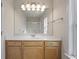 Bathroom with white countertop, blonde wood cabinets and modern lighting at 1905 Cottage Grove Way, Cumming, GA 30040