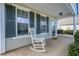Inviting front porch with white rocking chair and blue window shutters at 1905 Cottage Grove Way, Cumming, GA 30040