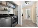 Well-lit laundry room featuring modern washer and dryer units and convenient shelving at 491 Lees Sw Trce, Marietta, GA 30064