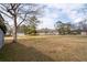 Large backyard showing the size of the lot, with mature trees and neighborhood homes visible at 116 Poplar St, Fairburn, GA 30213