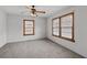 Cozy bedroom features two windows, a ceiling fan with lights, neutral walls and plush carpeting at 116 Poplar St, Fairburn, GA 30213