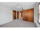 Bedroom featuring neutral colored walls, plush carpeting, and a closet with wood panel doors at 116 Poplar St, Fairburn, GA 30213