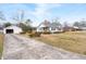 Quaint home with a long driveway and a detached garage, surrounded by a grassy yard at 116 Poplar St, Fairburn, GA 30213