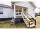 View of the front of the home with a small covered porch and newly constructed stairs at 116 Poplar St, Fairburn, GA 30213