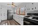 Traditional style kitchen with white cabinets, stainless steel refrigerator, and a black gas range at 116 Poplar St, Fairburn, GA 30213