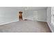 Open-concept living room with gray carpet, light gray walls and access to other rooms at 116 Poplar St, Fairburn, GA 30213