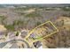 Aerial view of a home with a turfed lawn, positioned in a wooded area within a developed neighborhood at 1348 Ewing Creek Dr, Dacula, GA 30019