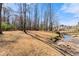 Large lot featuring open space with a small creek and mature trees at the edge of the property at 1348 Ewing Creek Dr, Dacula, GA 30019
