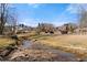 View of the backyard and creek with homes in the distance behind a rod iron fence at 1348 Ewing Creek Dr, Dacula, GA 30019