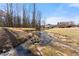 Spacious backyard with a creek, trees and view of the home at 1348 Ewing Creek Dr, Dacula, GA 30019