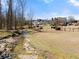 Scenic backyard view featuring a creek, iron fence, and expansive grassy area with home exteriors beyond at 1348 Ewing Creek Dr, Dacula, GA 30019