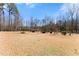 Large grassy backyard with mature trees and shrubs, offering an abundance of space for recreation and privacy at 1348 Ewing Creek Dr, Dacula, GA 30019