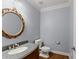 Powder room with granite countertop, hardwood floors, and an ornate mirror at 1348 Ewing Creek Dr, Dacula, GA 30019