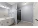 Bathroom with white vanity, framed mirror, and glass-enclosed shower at 1348 Ewing Creek Dr, Dacula, GA 30019
