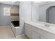 Bathroom features soaking tub with tiled surround, vanity, and tile floors at 1348 Ewing Creek Dr, Dacula, GA 30019