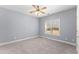 Bright bedroom with gray carpet, a ceiling fan, and a window at 1348 Ewing Creek Dr, Dacula, GA 30019
